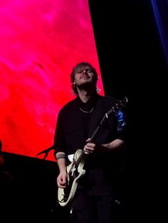 a man playing an electric guitar on stage