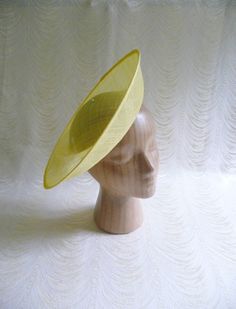 One contoured saucer with an upturned brim hat sinamay straw fascinator / hat base in yellow that measures approximately 12" (30.5 cm) in diameter. The base is contoured to fit against the head. The edges of the brim are finished in sinamay. The multi-layer stiffened sinamay straw has a great sturdy weave and provides excellent support for your millinery creations. This is NOT a ready to wear finished hat and it will not stay on your head unless you add a head band to wear. Add embellishments of your choice. ASinamay is a natural material and you may see some color striations in the weave. This is not a defect, but is the result of how different natural fibers respond to dye.  nice high quality base - I know you'll be pleased! This hat base is listed separately in fuchsia pink, white, cora Spring Adjustable Sinamay Fascinator, Adjustable Sinamay Top Hat For Summer, Spring Sinamay Fascinator, Spring Sinamay Fascinator Hat, Sinamay Fascinator Hat For Spring, Fitted Sinamay Brimmed Top Hat, Fitted Fedora Fascinator For Summer, Fitted Sinamay Boater Hat With Short Brim, Fitted Brimmed Costume Hats For Summer