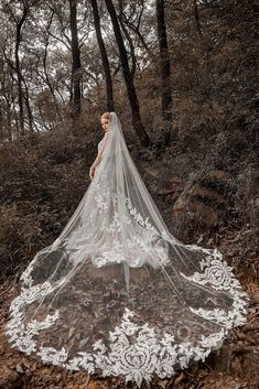 a woman wearing a wedding veil in the woods