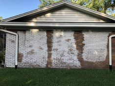 the side of a brick house that has been painted white and is covered in brown paint