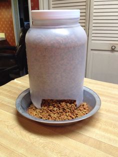 a plastic container filled with food sitting on top of a wooden table next to a metal plate