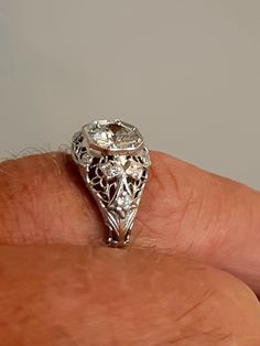 A wonderful Victorian band with great filigree detail. The center stone measures out at .80 ct and has a clarity of SI1 and G color. There is a small natural crystal on the girdle. On either side are 2 @.05ct diamonds set in diamond shape gold. The band weighs 2.5 grams and is is excellent condition. It measures 8.5mm across the top. Antique White Gold Diamond Jewelry, Antique Jewelry In Diamond White With Brilliant Cut, Ornate Brilliant Cut Diamond Ring, Vintage Diamond Jewelry With Center Stone, Exquisite Filigree Ring With Intricate Design, Formal Wedding Ring With Diamond Accents And Round Stone, Brilliant Cut Diamond Jewelry For Marriage, Wedding Diamond Jewelry With Intricate Design, Formal White Topaz Wedding Ring With Diamond Accents