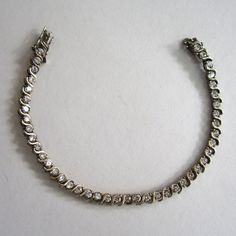 "Sparkly, shimmery fun for a fraction of the price of real diamonds! This tennis bracelet is made of sterling silver and is set with bright glass stones in a line Very well-made. Marked 925 in a couple places near the clasp. Excellent condition. Two safety clasps keep the bracelet securely on your wrist. Measures 7 1/2\" in length and 1/8\" wide." Formal Sparkling Sterling Silver Diamond Bracelet, Sparkling Sterling Silver Diamond Bracelet For Anniversary, Sparkling Sterling Silver Bracelets For Anniversary, Silver Sparkling Diamond Bracelet For Anniversary, Sparkling Silver Diamond Bracelet For Anniversary, Formal Sterling Silver Sparkling Diamond Bracelet, Formal Sparkling Diamond Bracelet In Sterling Silver, Classic Silver Sparkling Diamond Bracelet, Silver Sparkling Tennis Bracelet For Anniversary