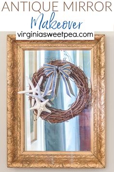 an antique mirror with a wreath and starfish on it