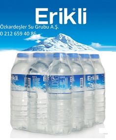 six bottled water bottles are stacked on top of each other in front of a mountain