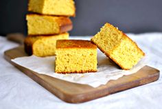 four pieces of cake sitting on top of a wooden cutting board