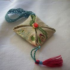 an ornament with tassels on it sitting on a white tablecloth