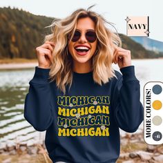 a woman wearing a michigan sweatshirt and sunglasses