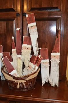 a basket filled with wooden santas sitting on top of a table