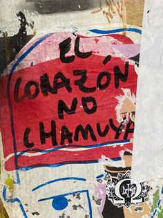 graffiti on the side of a building with words written in spanish and english, along with an image of a man holding a surfboard