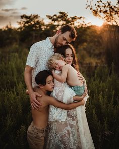 a family hugging each other in the middle of a field