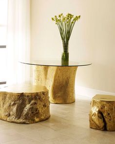 two tables made out of logs with flowers in the vase on one side and another piece of drift wood on the other