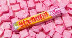 a tube of pink candy sitting on top of a pile of pink cubes