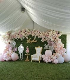 a table with balloons, chairs and flowers on it