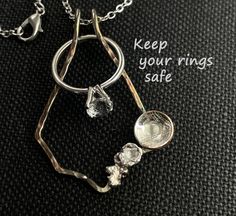 a silver necklace with some glass beads hanging from it's sides and the words keep your rings safe