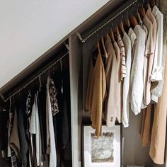 an organized closet with clothes hanging on hooks