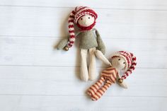 an image of two dolls laying on the floor with one holding the other's hand