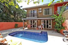 a house with a pool and hammock in the backyard