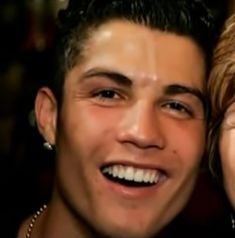 a man and woman smiling at the camera with their faces close to each other,