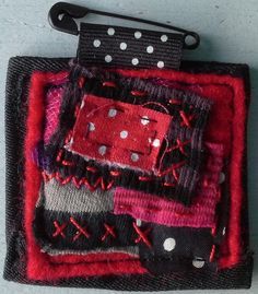 a red and black piece of cloth with white dots on it, sitting on a gray surface