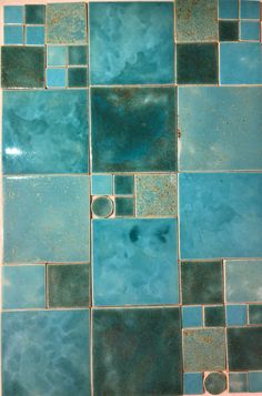 a tile floor with blue and green tiles on the bottom, in different sizes and colors