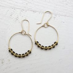 Add some bohemian flair to your look with our Boho Hoops in gold featuring stunning ice obsidian gemstones. Perfect for any occasion, these playful earrings are sure to turn heads and bring good vibes. 14k Gold Filled Wire Measure approximately 1.125" in diameter Earrings Hang 1.75" from top of ear wire Ice Obsidian Gemstones Polished to a high shine Sent in a Gift Box with Polishing Cloth Handmade in Montana Bohemian Handmade Brass Hoop Earrings, Gold-tone Hoop Earrings With Brass Ear Wire, Adjustable Bohemian Obsidian Jewelry, Handmade Obsidian Round Beads Jewelry, Bohemian Black Brass Earrings, African Turquoise, Ear Wire, Jewelry Packaging, Christmas Shopping