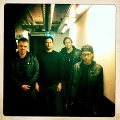 a group of men standing next to each other near a wall in an office building