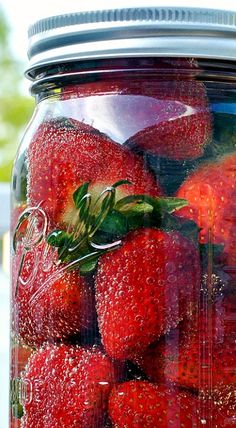 a jar filled with lots of ripe strawberries