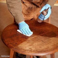 a person in blue gloves is cleaning a stool