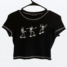 Black Cropped T-Shirt With Skeletons On Skateboard On The Front. A Size Small. Fitted Trendy T-shirt With Skull Print, Black Stretch Tops With Skull Print, Black Stretch Top With Skull Print, Casual Fitted Tops With Skull Print, Casual Black Tops With Skull Print, Casual Fitted Skull Print Tops, Fitted Casual Tops With Skull Print, Casual Black Skull Print Tops, Fitted Graphic Tee With Skull Print