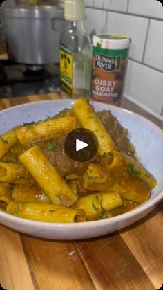 a white bowl filled with pasta on top of a wooden table