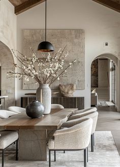 a dining room table with chairs and a vase on it