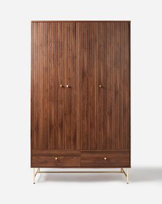 the armoire is made from wood and has brass legs