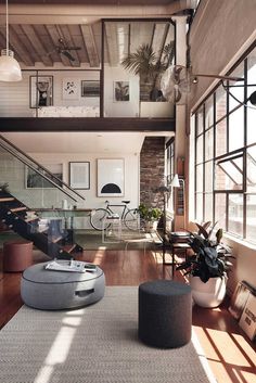 a living room filled with furniture and lots of windows on top of a wooden floor