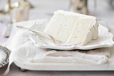 a piece of cake sitting on top of a white plate next to a silver spoon