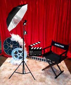 a chair and umbrella sitting on top of a white rug next to a red curtain