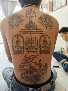 the back of a person's body with tattoos on it and other things behind them