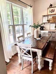 a dining room table with two benches in front of it and a window behind it