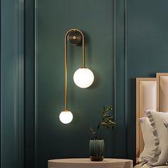 a bedroom with green walls and two lights on the wall, one light is turned on