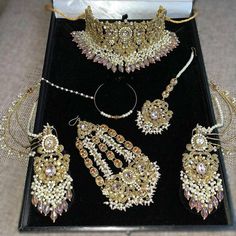 an assortment of gold jewelry on display in a black box with the words jewelsbylabba sponsored above it