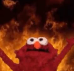 the sesame character is standing in front of a fire with his arms up and eyes wide open