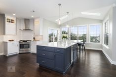 a large kitchen with an island in the middle and lots of windows on both sides