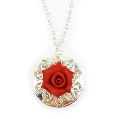 This handcrafted Rose Locket Necklace features a hand sculpted rose (available in many colors) with filigree backdrop on a shiny silver tone locket. Add photos of your loved ones to this special jewelry design. -Locket : 2cm (approx. 3/4 inch) silver-plated locket -Interior Locket (for photo) : 13mm (1/2 inch) -Cable Chain : Choose silver plated or upgrade to 925 sterling silver -Chain Length : Choose 16 inch or 18 inch from drop-down box. -Pictured Color : Apple Red Flowers are hand sculpted wi Silver Flower Necklace With Rose Design For Gift, Silver Rose Design Flower Necklace As Gift, Silver Rose Design Flower Necklace For Gift, Silver Elegant Locket Necklace With Flower Charm, Silver Round Pendant With Rose Design, Silver Necklace With Rose Design, Elegant Silver Locket Necklace With Flower Charm, Silver Flower Charm Necklace For Valentine's Day, Valentine's Day Silver Flower Charm Necklace