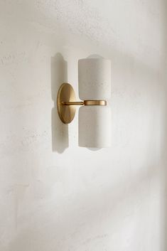 two light fixtures mounted on the wall in a room with white walls and flooring