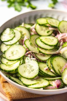 a white bowl filled with cucumbers and onions