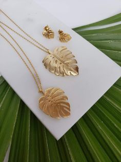 Gold plated monstera leaf necklaces + earrings. Necklace 1 is matte gold plated (brass), and necklace 2 is brushed gold plated (brass), and is slightly curved. The chains are both 18" long, with a 1.5" extender. The earrings are matte gold plated brass, and can have dangling 4mm bicone Swarovski crystals added in a variety of colors for no extra charge.  Gift wrapped. Gold Plated Leaf-shaped Jewelry, Gold Leaf Shaped Brass Jewelry, Gold Leaf-shaped Brass Jewelry, Gold Leaf Shaped Metal Jewelry, Jewellery Sets, Leaf Necklace, Monstera Leaf, Matte Gold, Cute Shoes