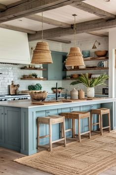 a kitchen with blue cabinets and wicker baskets hanging from the ceiling over the island