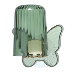 a green glass light with a butterfly on it's back and wings hanging from the side