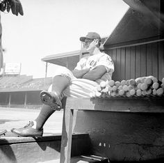 a man sitting on top of a bench next to a pile of fruit