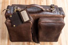 Fly in style next time you take a business trip or vacation with our limited edition brown Leather Flight Bag. This leather bag is finely handcrafted from the highest quality American Bison hides and 100% Made in USA. Any artisan that plays a part in handcrafting your flight bag adds their initials inside, making each flight bag unique. Each handmade vintage leather flight bag fits perfectly in an overhead compartment of an airplane so you can travel quick and easy with this carry on bag. Not on Travel Shoulder Bag With Leather Backing In Distressed Brown, Vegetable Tanned Leather Travel Backpack, Rectangular Vegetable Tanned Leather Backpack For Travel, Leather Travel Bags With Interior Card Slots, Luxury Brown Travel Bag With Leather Backing, Luxury Brown Leather Backpack For Trips, Rectangular Vegetable Tanned Leather Satchel For Travel, Luxury Leather Rectangular Backpack For Trips, Luxury Rectangular Leather Backpack For Trips